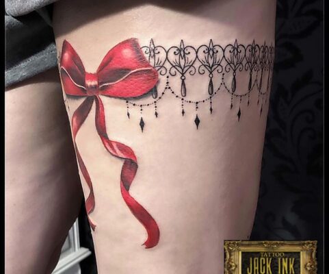 Tatuaj bratara din mandala pe picior cu fundita rosie